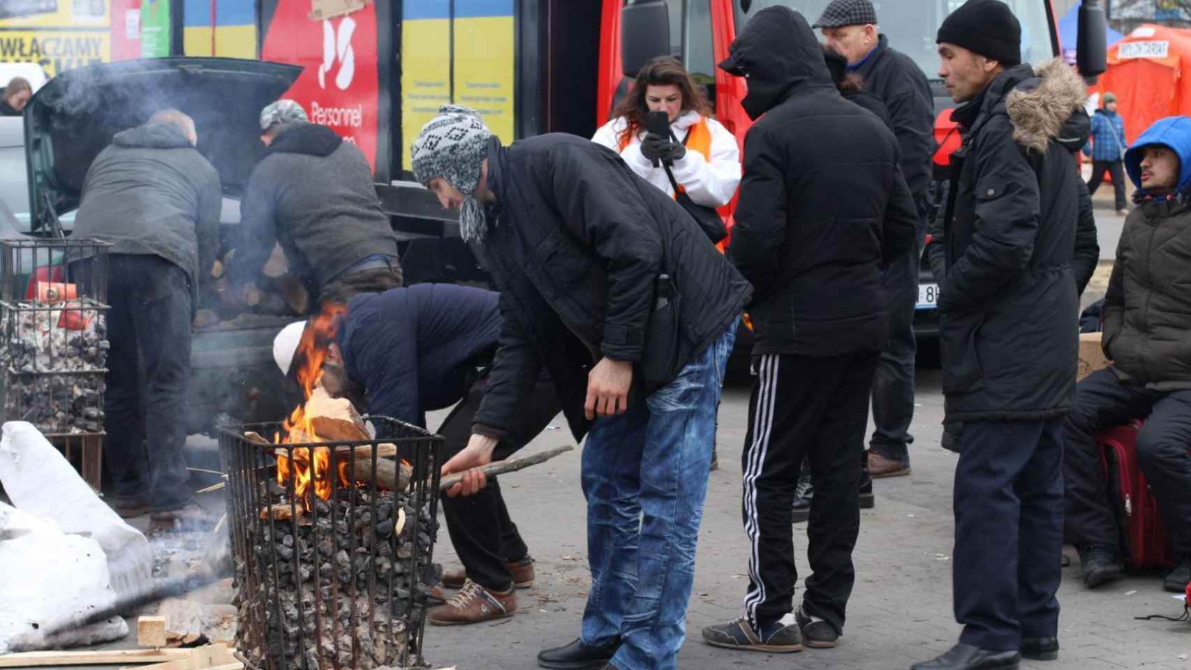 Unos ucranianos se calientan con un fuego del bidón.