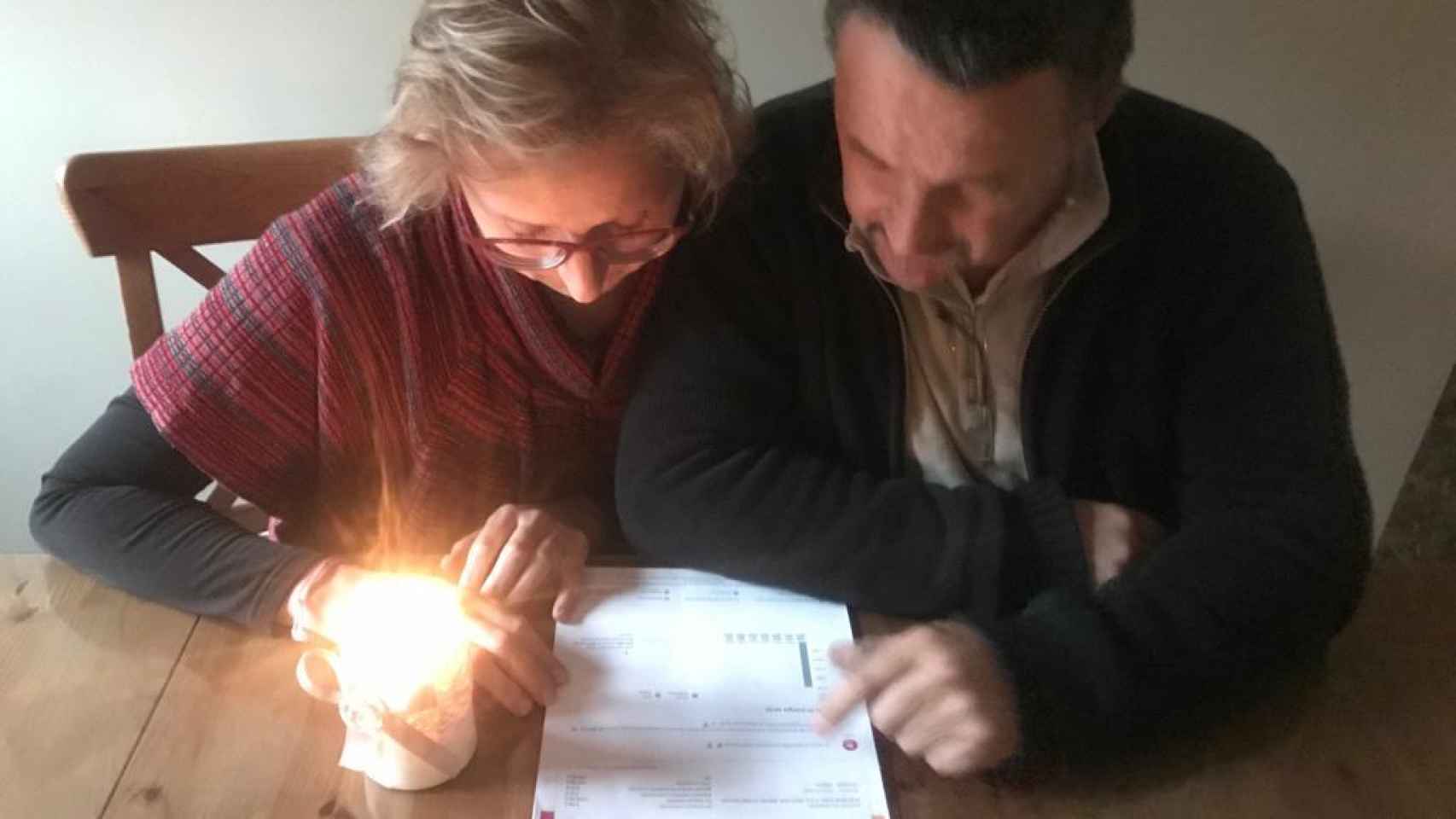 María Belén y Paco repasando la factura, junto a una vela.