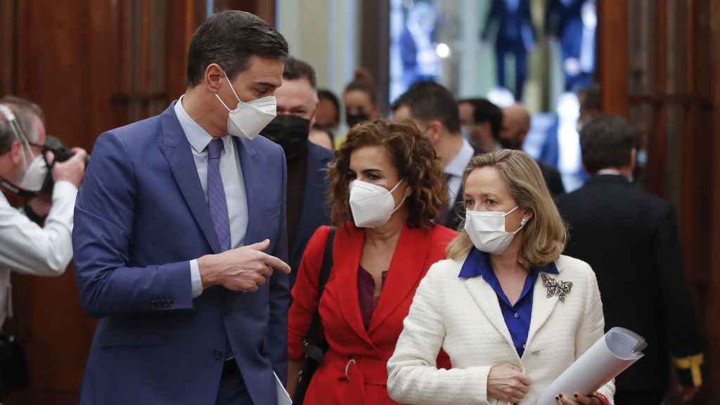 Pedro Sánchez, María Jesús Montero y Nadia Calviño en los pasillos del Congreso de los Diputados.