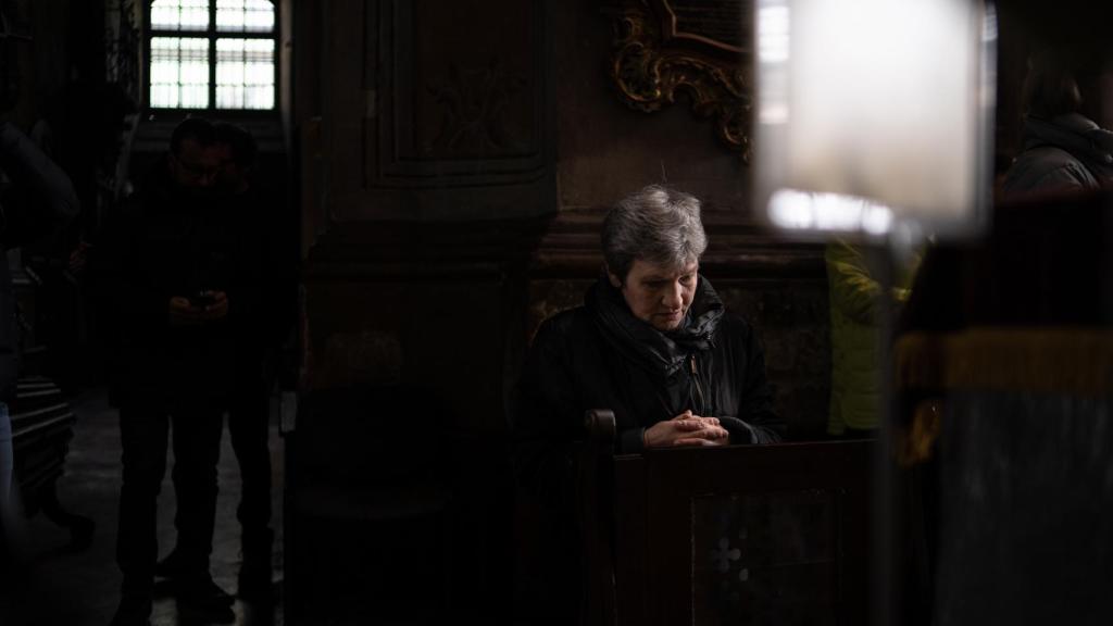 Una mujer reza en la catedral de San Pedro y San Pablo de Lviv durante el funeral de un soldado fallecido en la guerra.