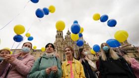 Varias personas lanzan globos al aire como gesto para el fin de la guerra en Ucrania, en la plaza del Obradoiro.