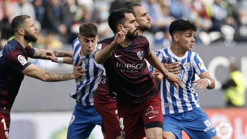 Roberto y Andrés Caro, entre los jugadores del SD Huesca.