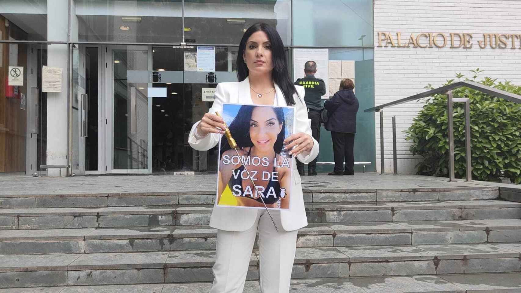 Nora, sujetando la cánula y una imagen de su hermana, Sara, en los juzgados de Cartagena.