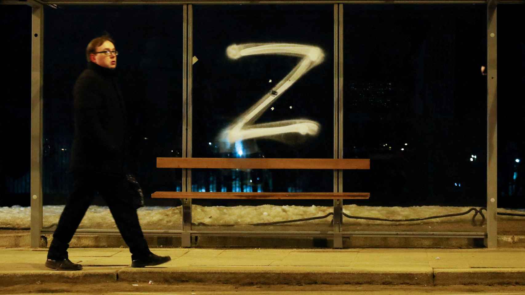 Un hombre pasa junto a un símbolo en apoyo a la invasión rusa en una parada de bus en San Petersburgo.