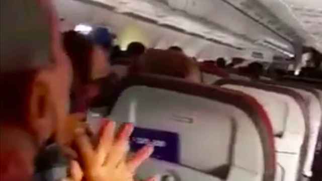 Uno de los pasajeros reza durante en angustioso aterrizaje.