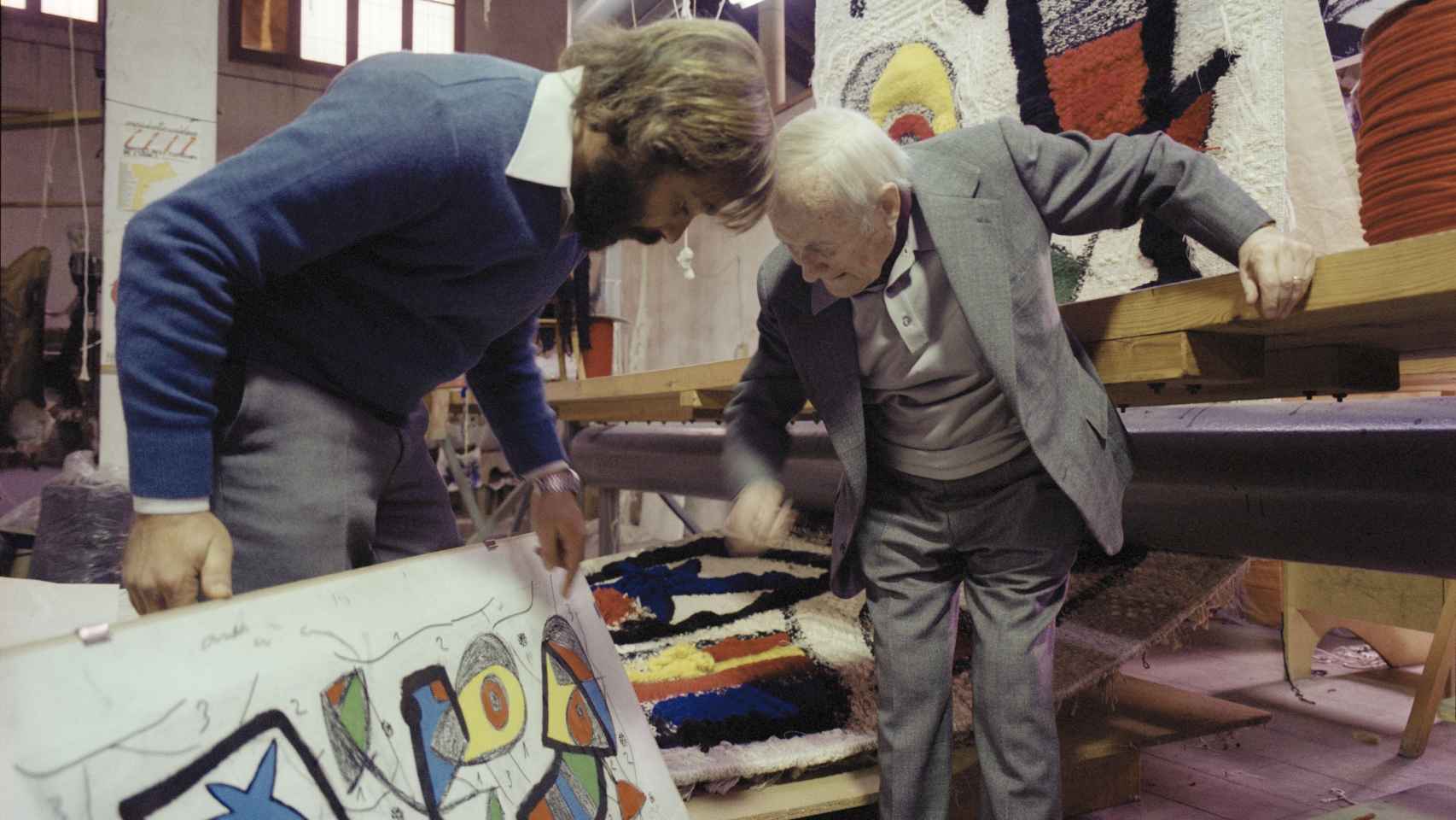 Joan Miró y Josep Royo en La Farinera con la maqueta y el tapiz. © Fons F. Català-Roca