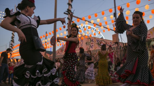 Tres mujeres bailando unas sevillanas.