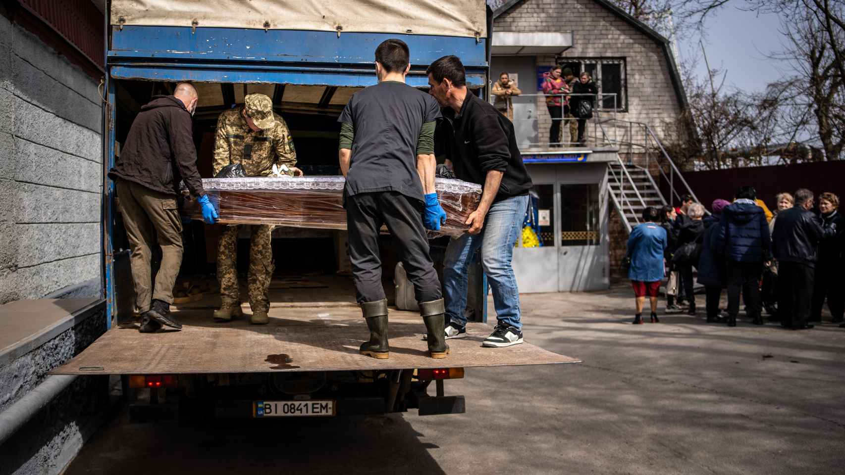 Trabajadores del instituto forense ayudan a un militar a introducir el féretro de un compañero en un camión que lo llevará a la región que le vio nacer.