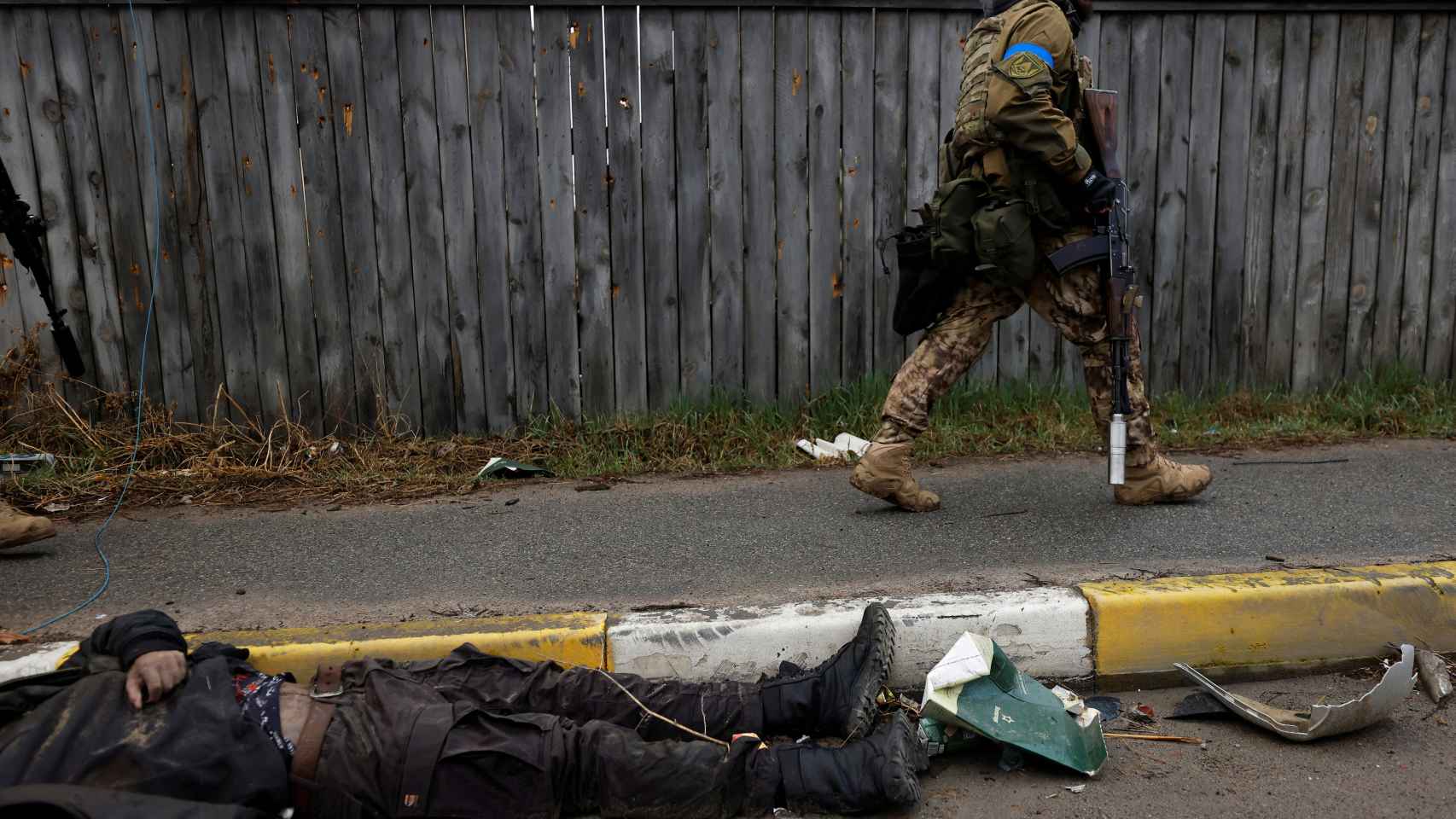 Un soldado ucraniano pasa junto al cuerpo de un civil fallecido.