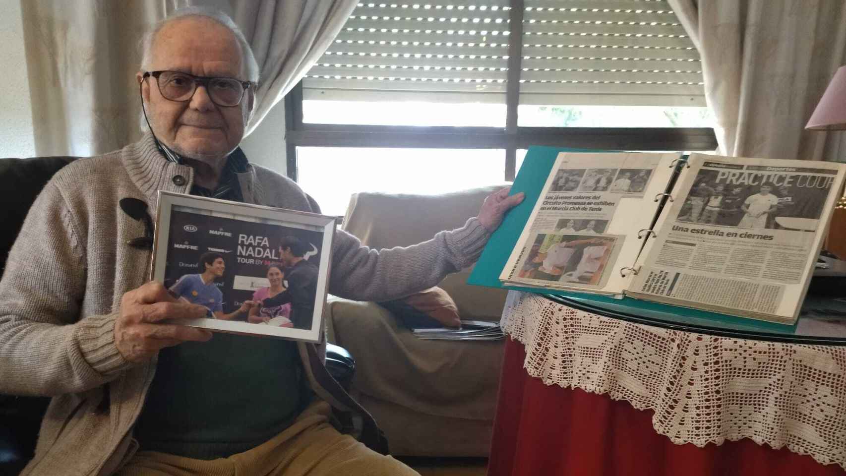 Carlos Alcaraz, abuelo del tenista Carlos Alcaraz, en el salón de su casa de la pedanía murciana de El Palmar, mostrando un álbum con recortes de prensa sobre los éxitos deportivos de su nieto.
