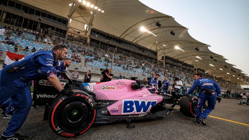 Los mecánicos de Alpine llevan el A522 de Fernando Alonso a la salida del Gran Premio de Bahréin