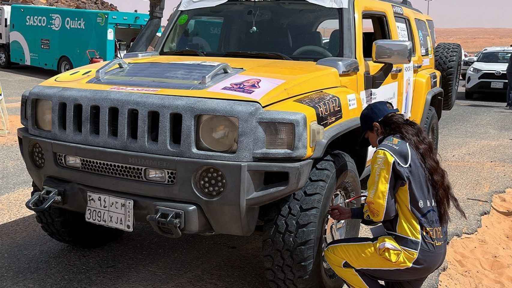 Una participante del Rally Jameel comprobando el estado de su vehículo