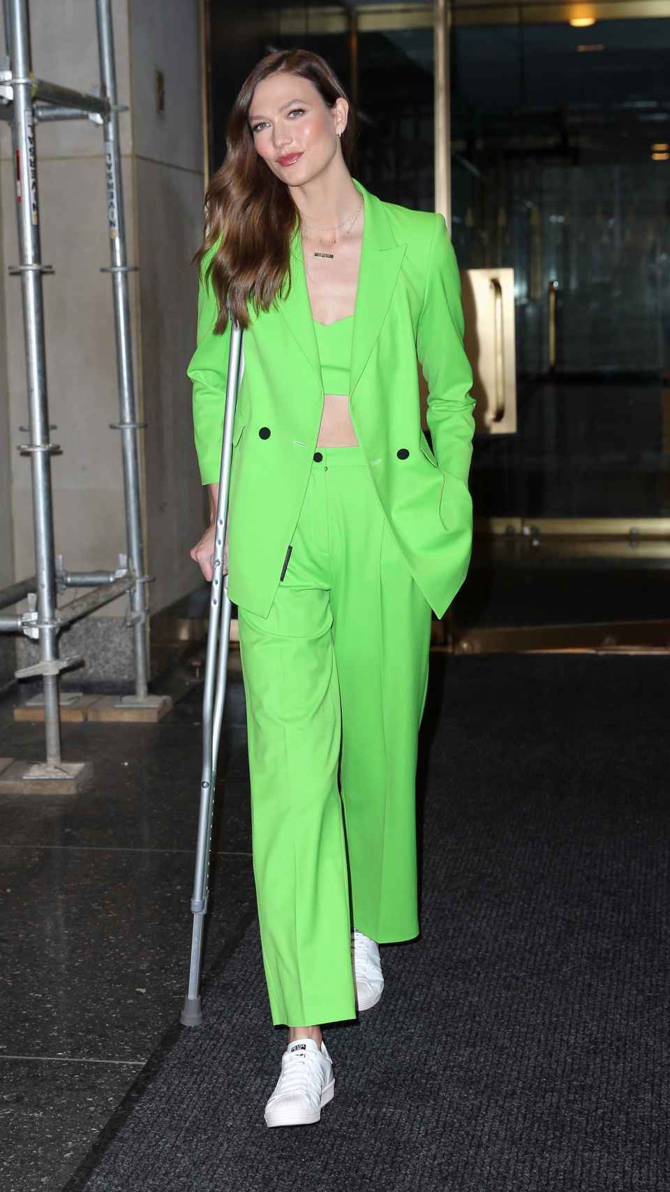 La modelo Karlie Kloss con traje verde neón y zapatillas de Prada.