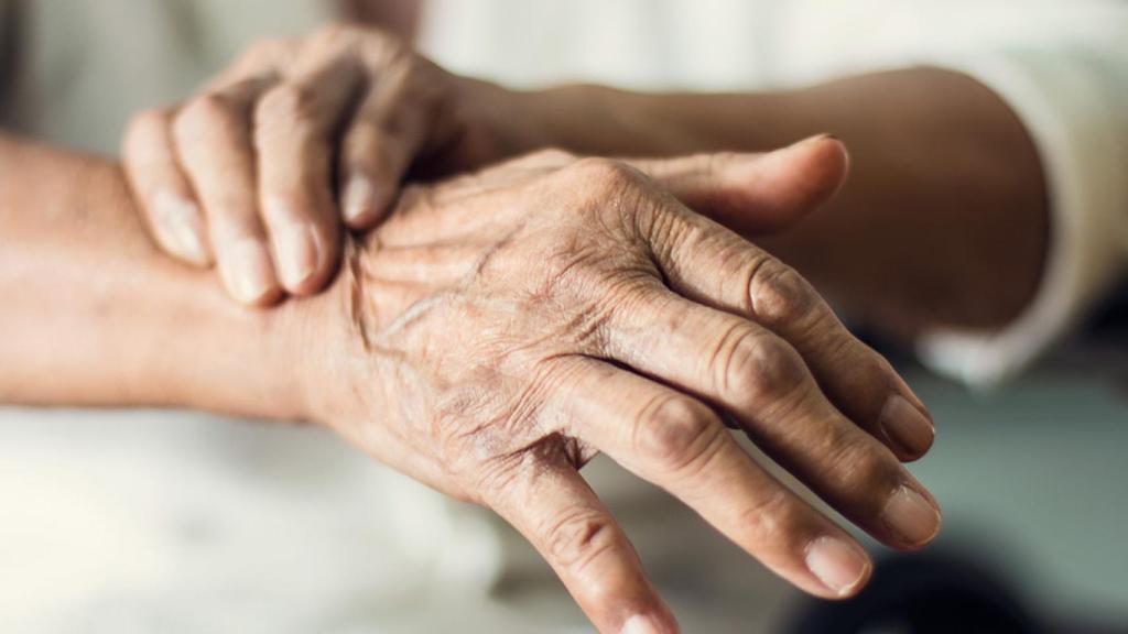 Una persona se sujeta la mano temblorosa fruto del párkinson.