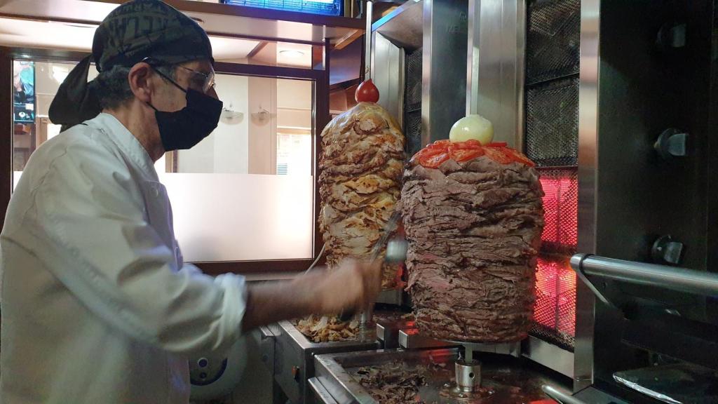 Georges, cortando un trozo de carne.