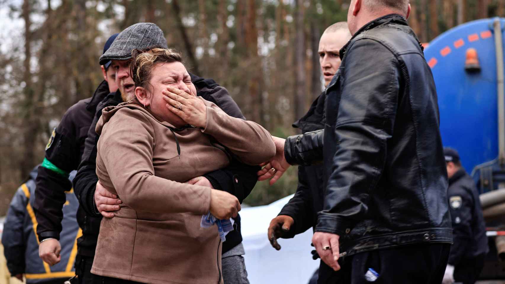 Cuatro personas intentan contener a Liudmila Zakabluk tras encontrar el cuerpo de su hijo en Buzova.