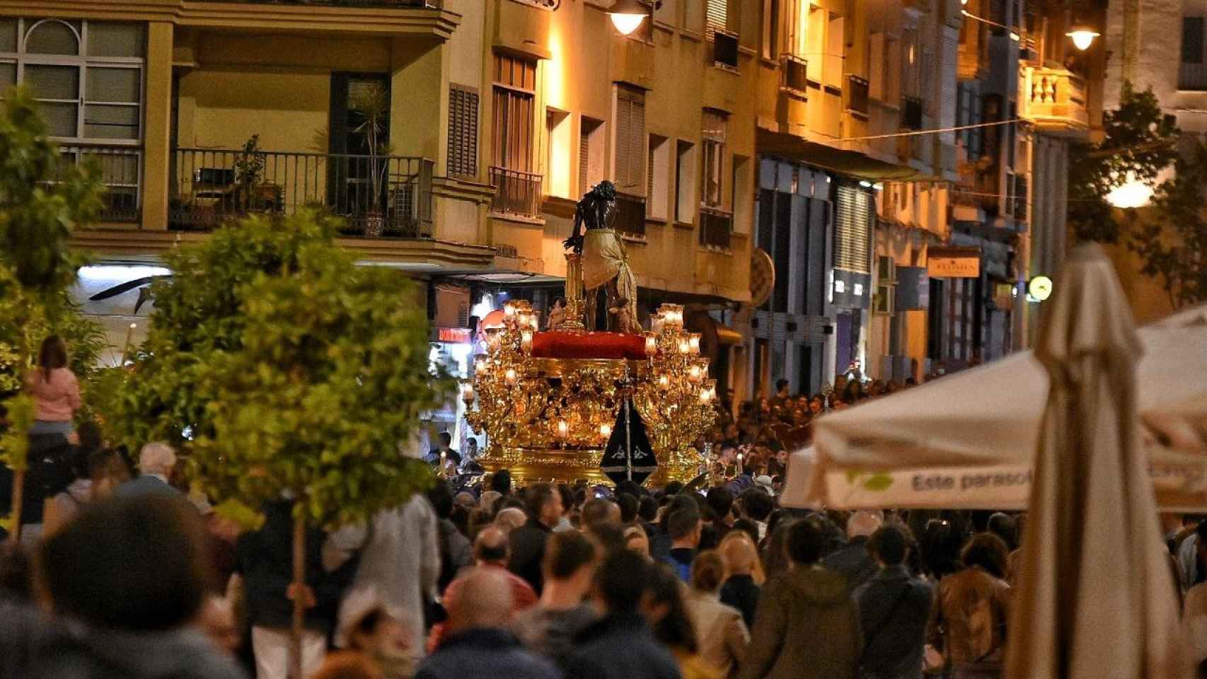 El Cristo de los Gitanos pasa junto a terrazas de hostelería en Málaga.