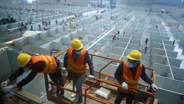 Trabajadores trabajan para convertir el Centro Nacional de Exposiciones de Shanghái, China, en un hospital improvisado  por la Covid-19.