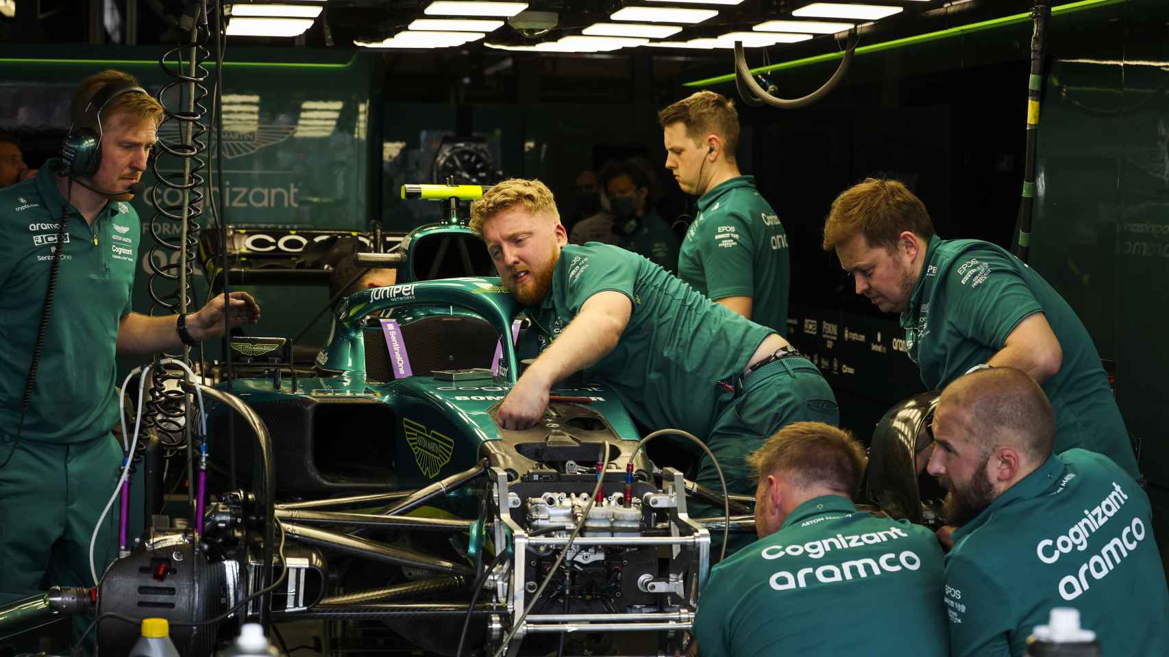 Los mecánicos de Aston Martin inspeccionando el coche de Sebastian Vettel