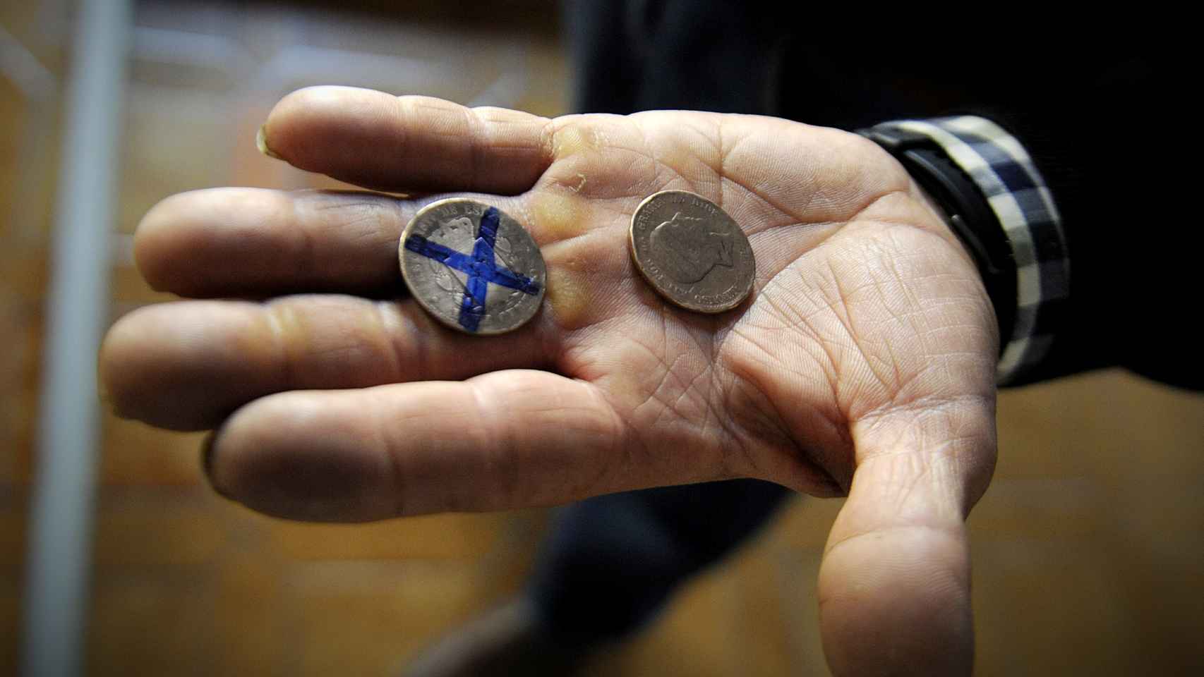 Un baratero muestra las monedas, que son todas originales de la época del Alfonso XII.