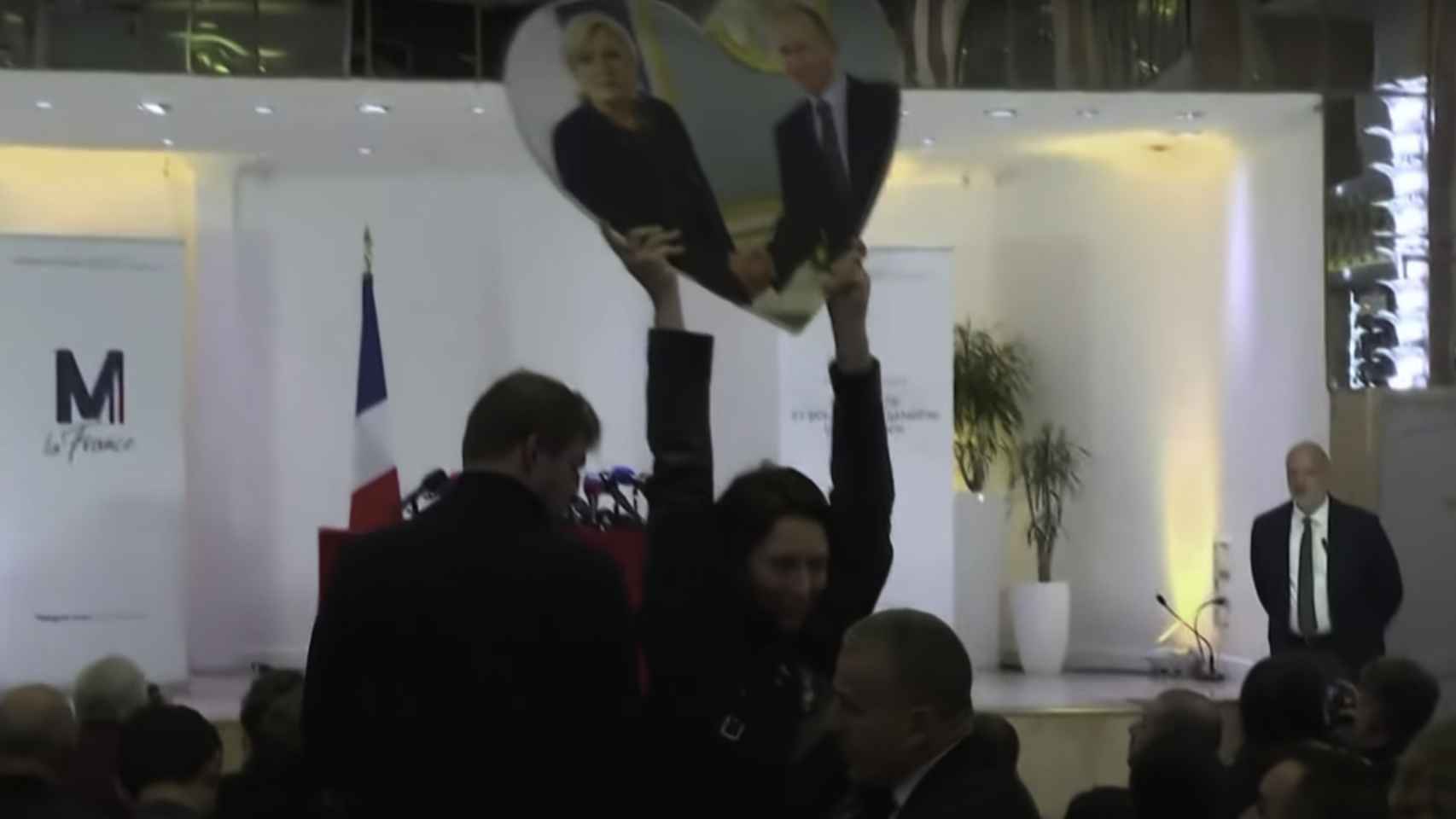 Momento en que una activista muestra una pancarta con forma de corazón con Le Pen y Putin.