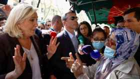 Marine Le Pen habla con una mujer en una visita a un mercado en Pertuis.