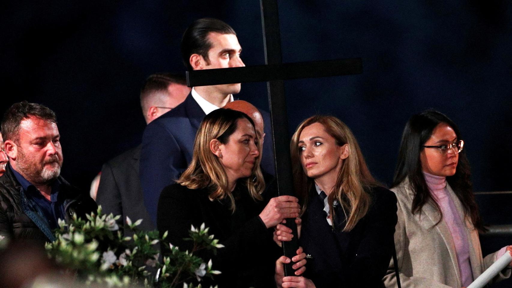 Una mujer ucranianas y otra rusa llevan una cruz mientras asisten a la procesión del Via Crucis.