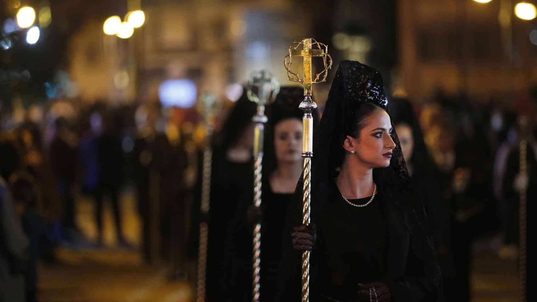Un grupo de Manolas acompañan la procesión del Santo Sepulcro de Alicante durante su recorrido el Viernes Santo por las calles del casco antiguo de Alicante.