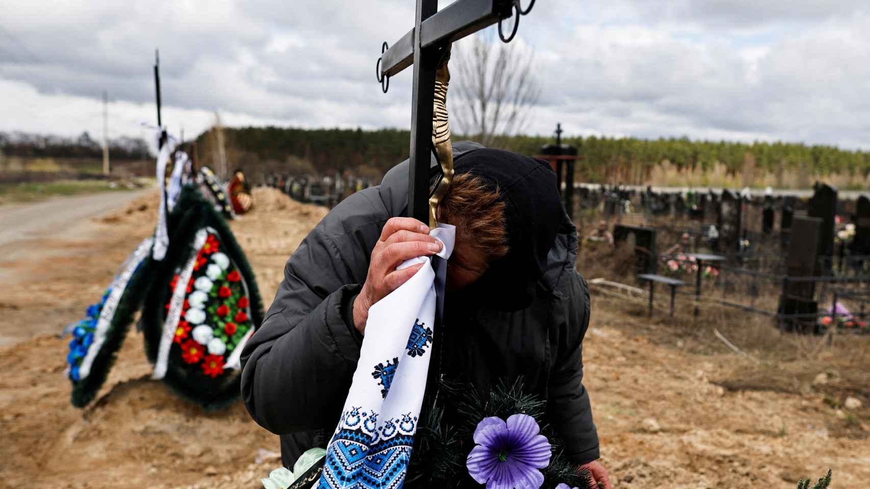 Una mujer ucraniana llora el cadáver de su hijo, asesinado por las tropas rusas.