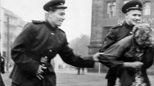 Soldados rusos acosan a una mujer alemana en Leipzig, en agosto de 1945.