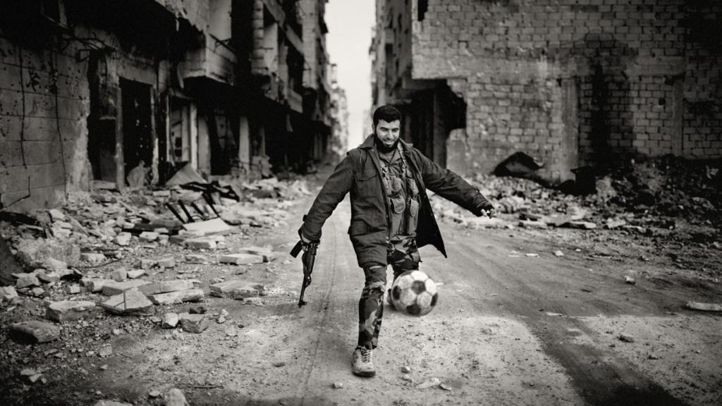 Un soldado juega al fútbol en una destruida Alepo.