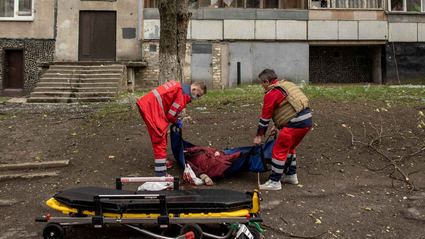 Los servicios de emergencias trasladan el cadáver de una mujer en Járkov.