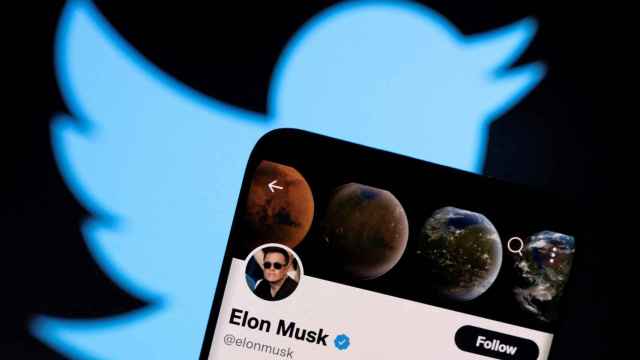 Imagen de la cuenta de Twitter de Elon Musk en un smartphone con el logo de la red social detrás.