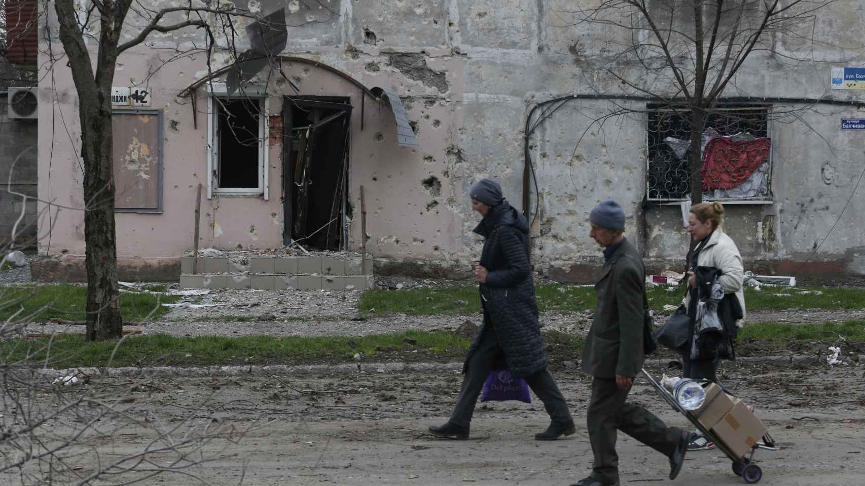 Residentes de Mariúpol huyen de la ciudad con sus pertenencias a cuestas.