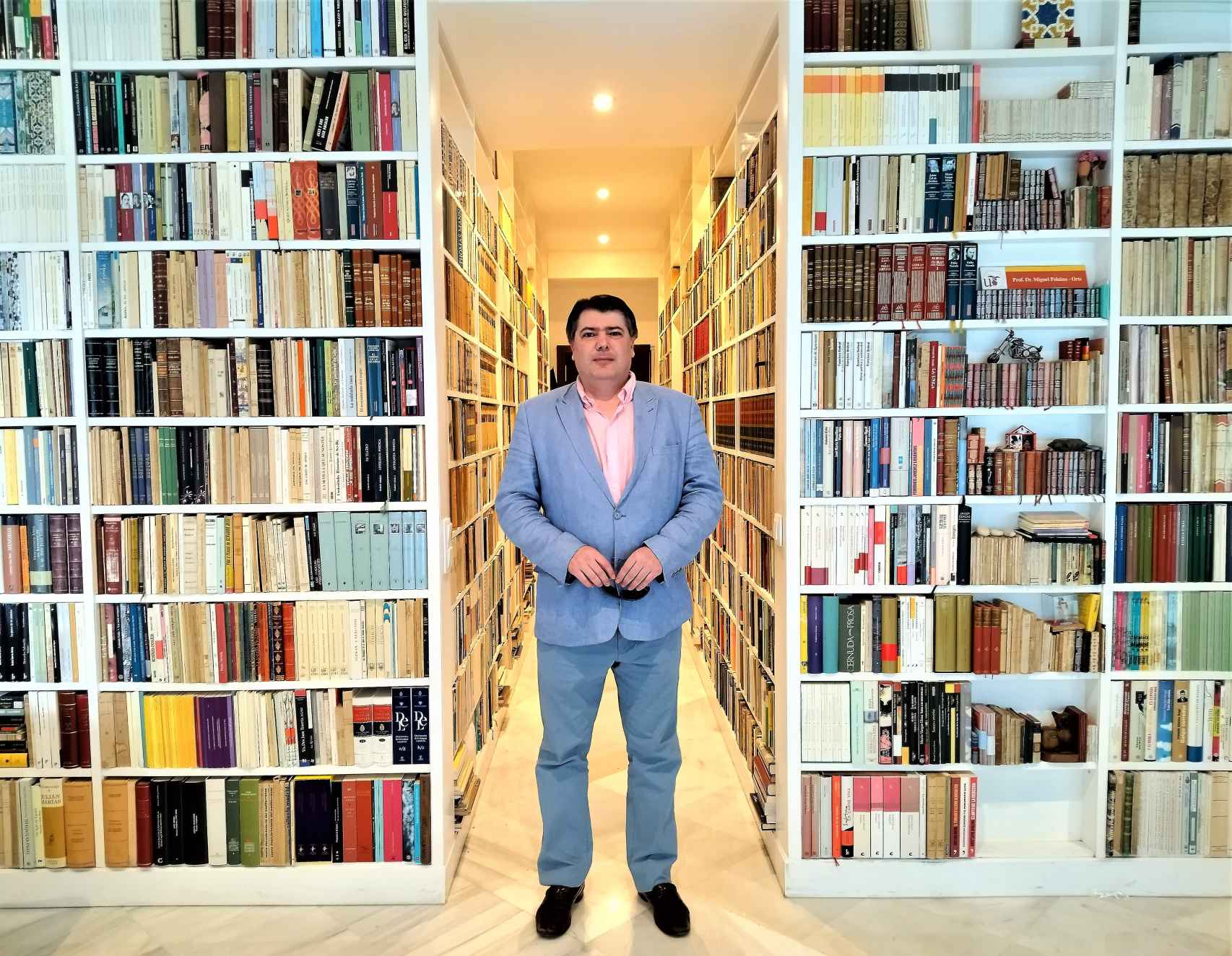 Miguel Polaino-Orts, junto a los libros que cubren las paredes de su piso en el centro de Sevilla.