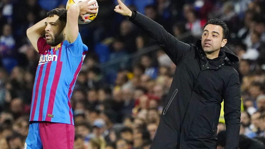 Jordi Alba realizando un saque de banda con Xavi dando órdenes al Barça