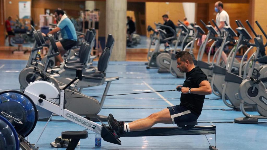 Varias personas practican deporte en máquinas en un gimnasio en Santiago de Compostela.