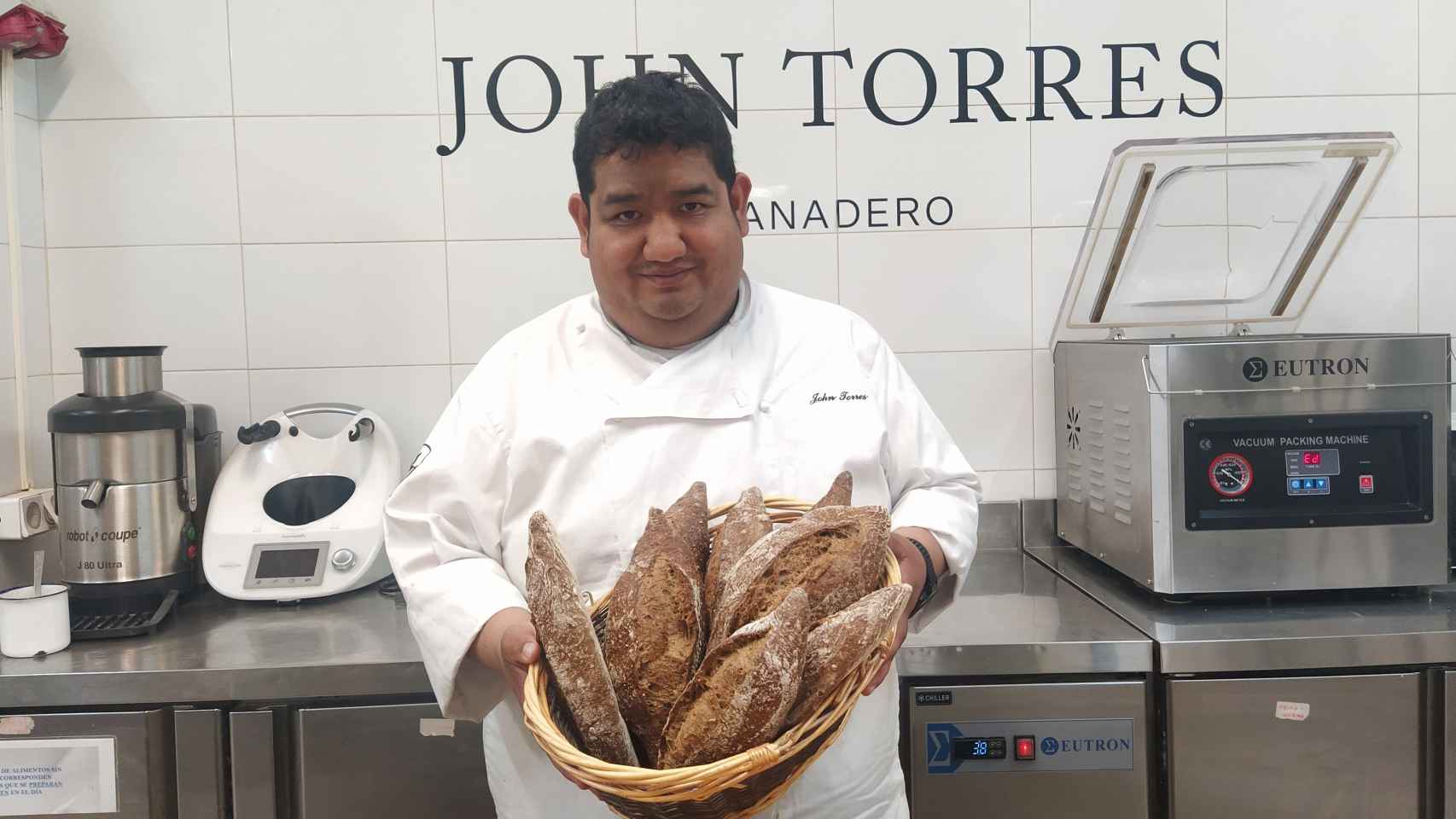 John Torres, que lleva unos 25 años siendo panadero, sujeta un cesto de pan artesanal.