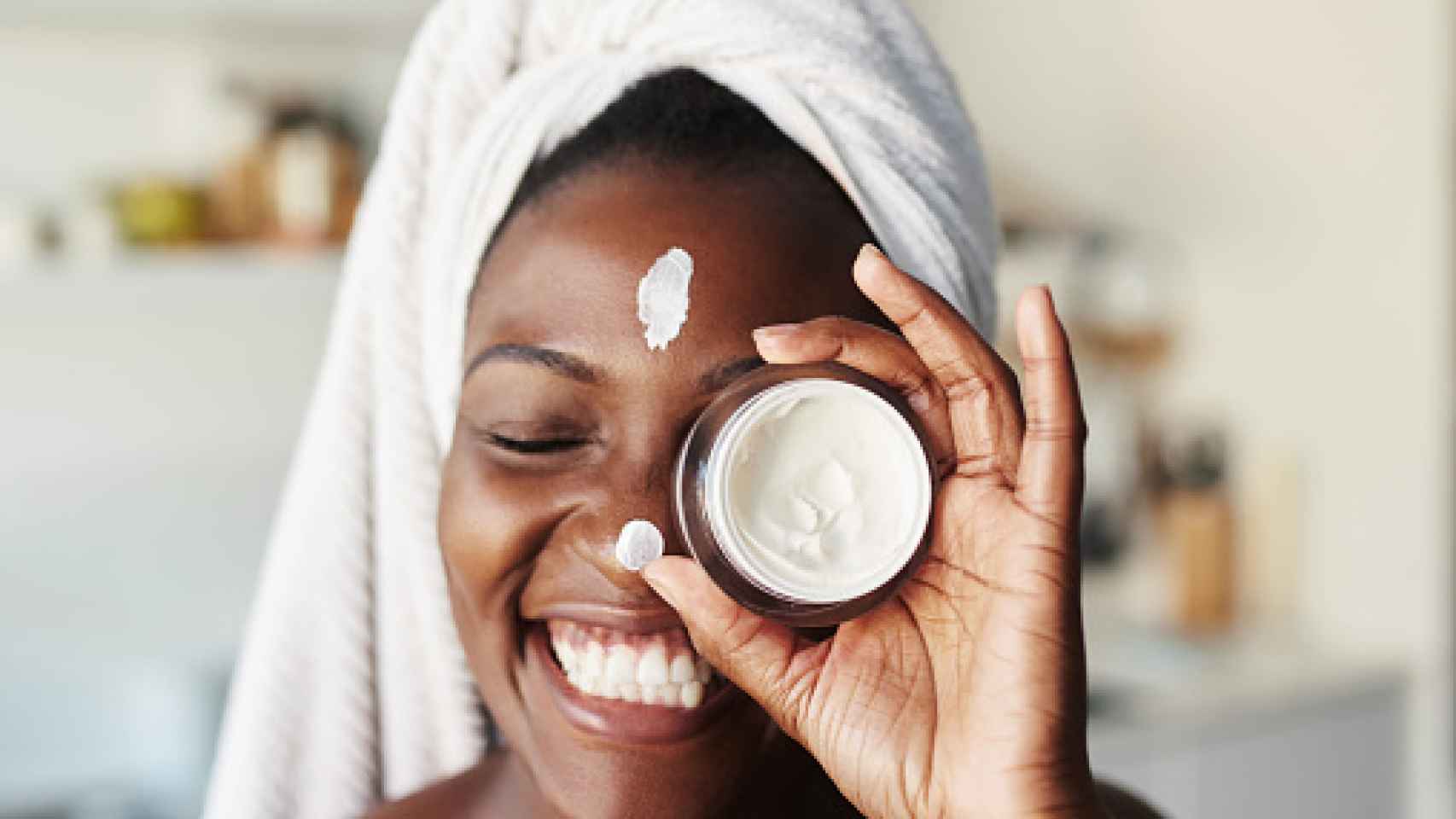 Una mujer utilizando crema facial.