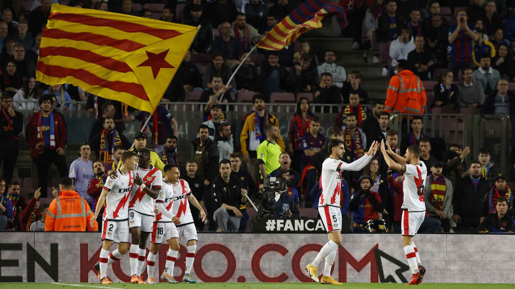 Los jugadores del Rayo Vallecano celebran su gol con una estelada de fondo