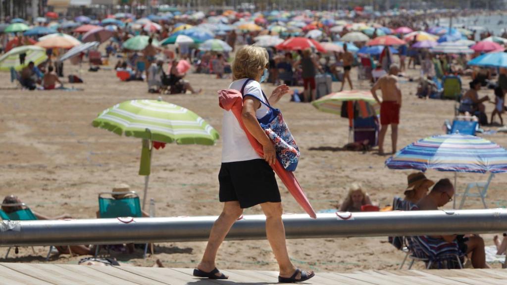 Turista entrando en la playa de Levante de Benidorm, en imagen de archivo.