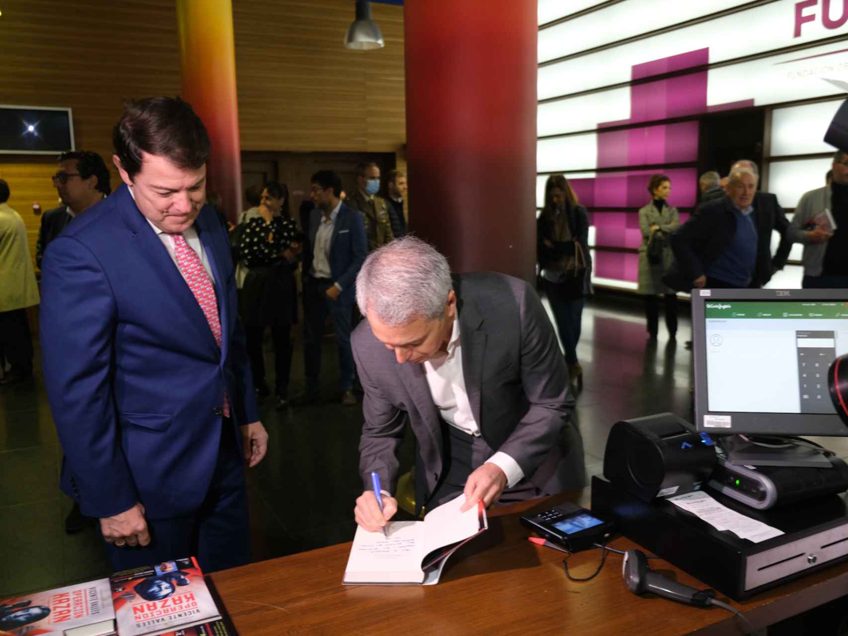 El periodista Vicente Vallés firma su libro al presidente de la Junta, Alfonso Fernández Mañueco, este miércoles en Valladolid.