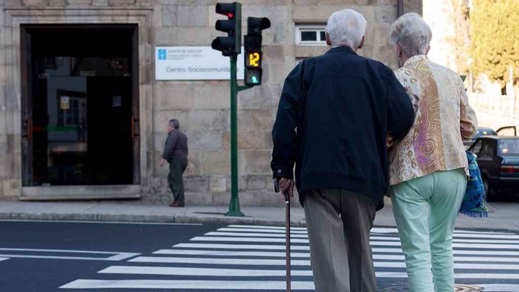 Dos ancianos cruzan un paso de peatones en España.