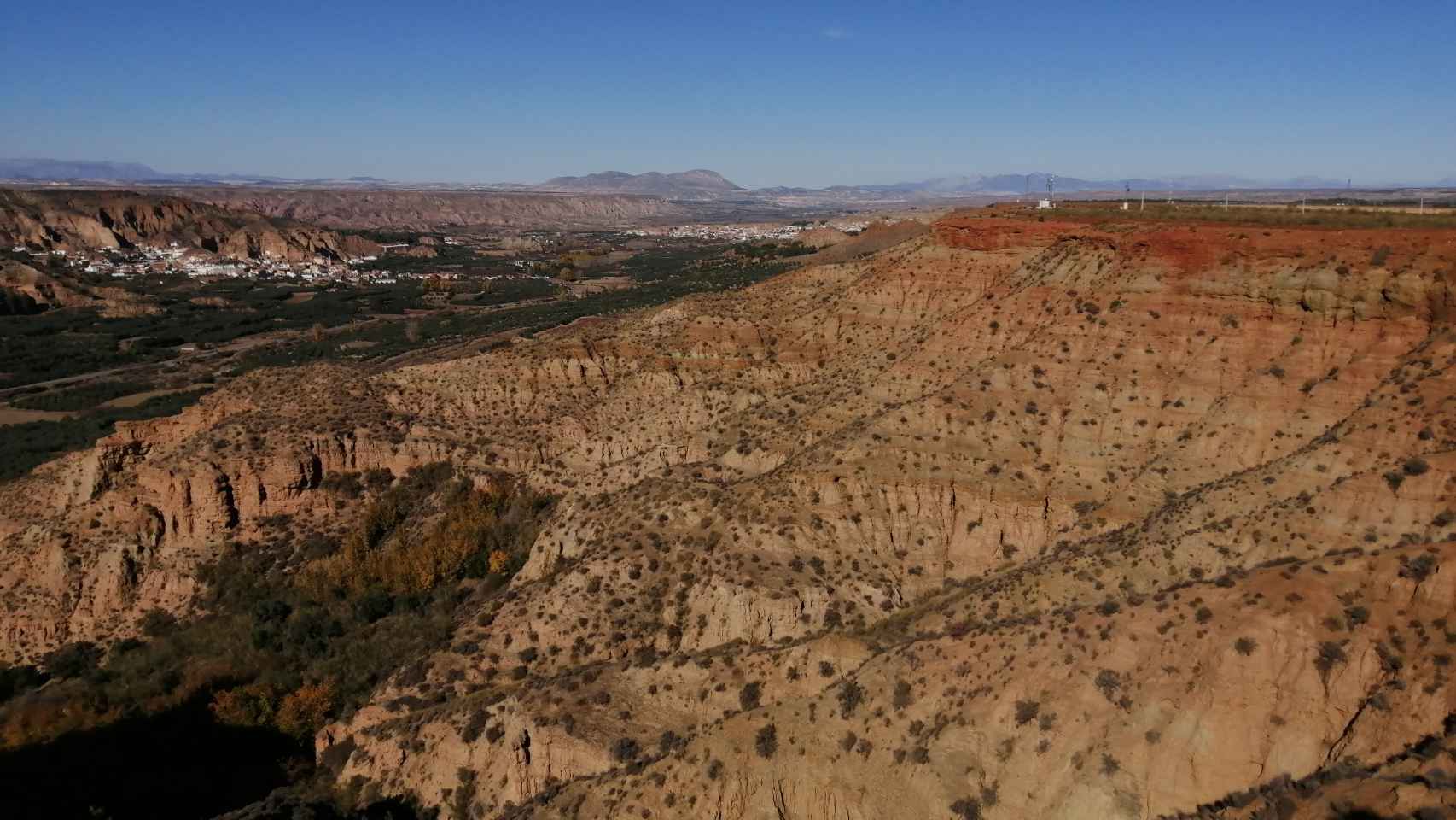 El tren atraviesa en la comarca de la Hoya de Guadix un paisaje de altiplano y cañones, al norte de Sierra Nevada.
