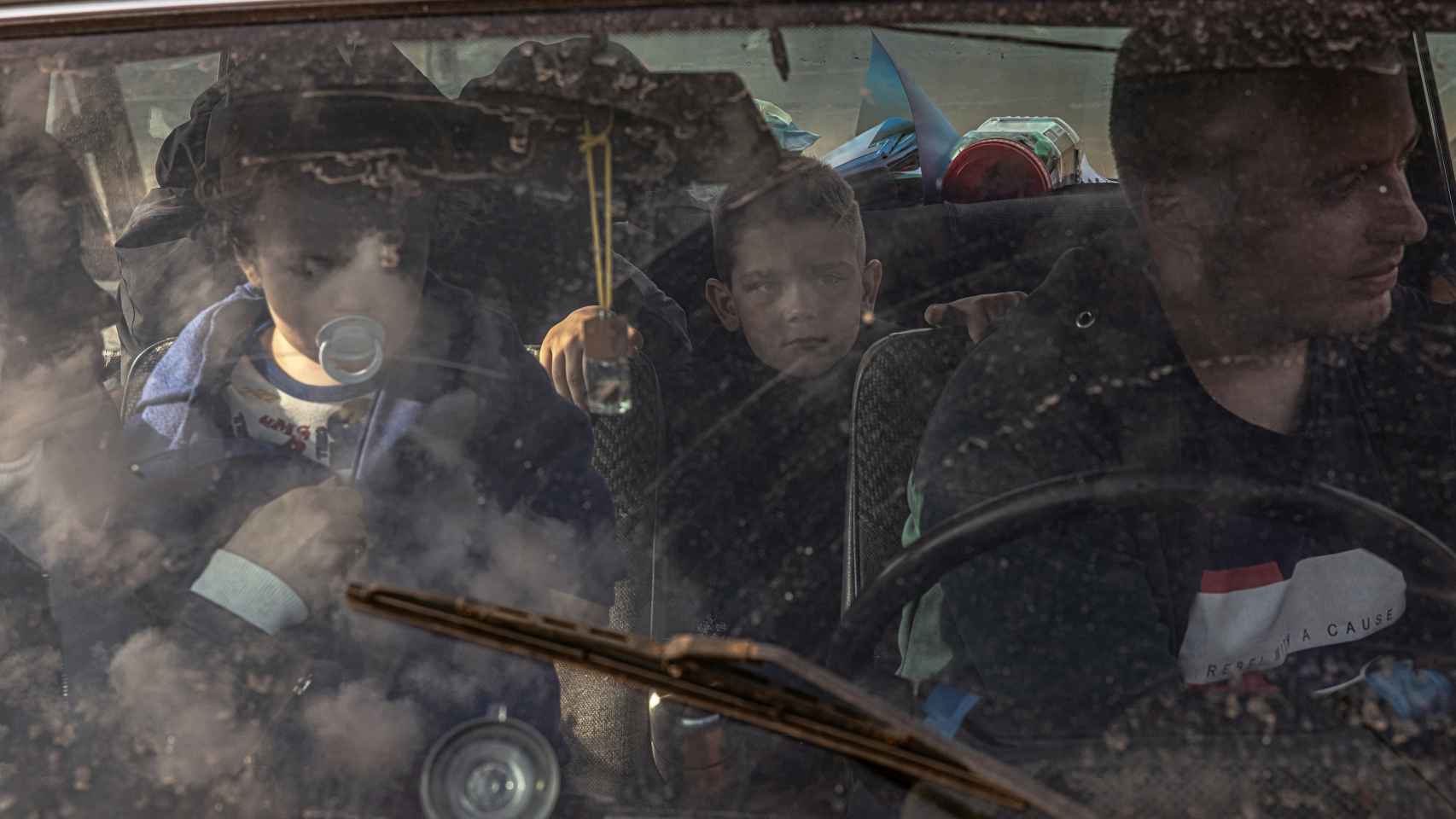 Una familia que huyó de la zona ocupada por Rusia en la región de Jersón se sienta en un coche tras llegar al punto de evacuación en Zaporiyia, Ucrania.