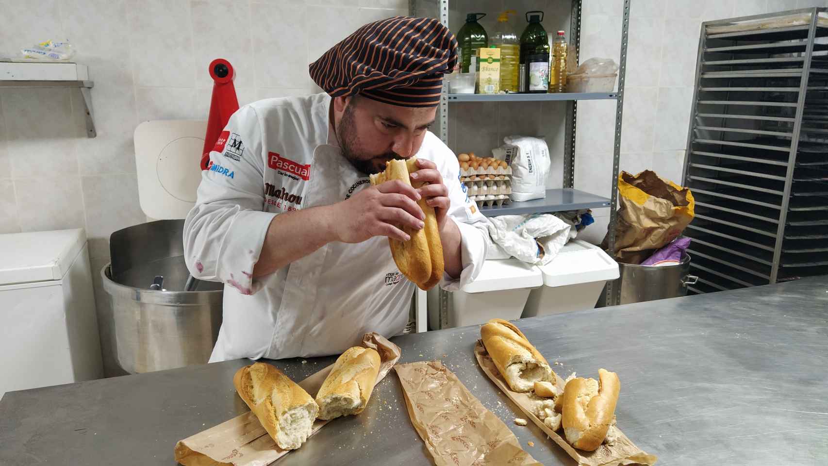 El panadero Julio López, oliendo una de las barras de pan de los 'chinos', para analizar su grado de cocción.