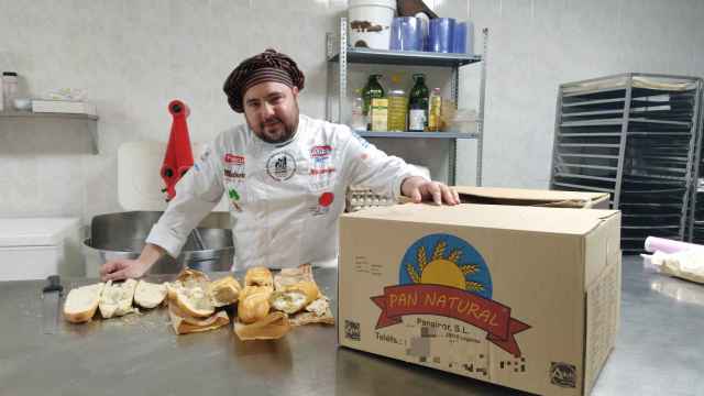 El panadero profesional Julio López, junto a tres barras de pan compradas en los 'chinos'.