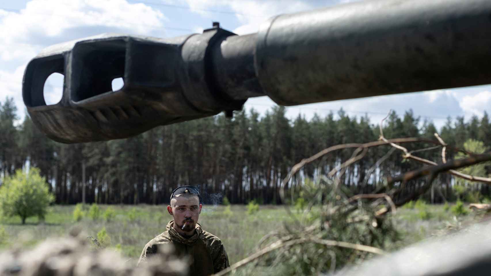 Un soldado ucraniano fumando junto a un tanque.