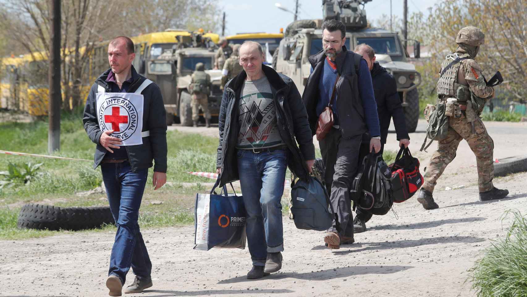 Civiles evacuados de Azovstal acompañados por un miembro de la Cruz Roja, este domingo.