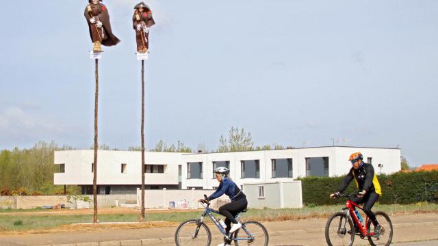 Dos mayos reciben a la entrada de Carbajal de la Legua a dos peregrinos del Camino de San Salvador